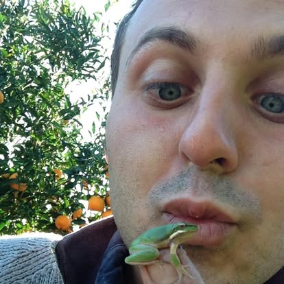 Un piccolo animale verde nella mano di Giuseppe Gallo durante il lavoro in farm